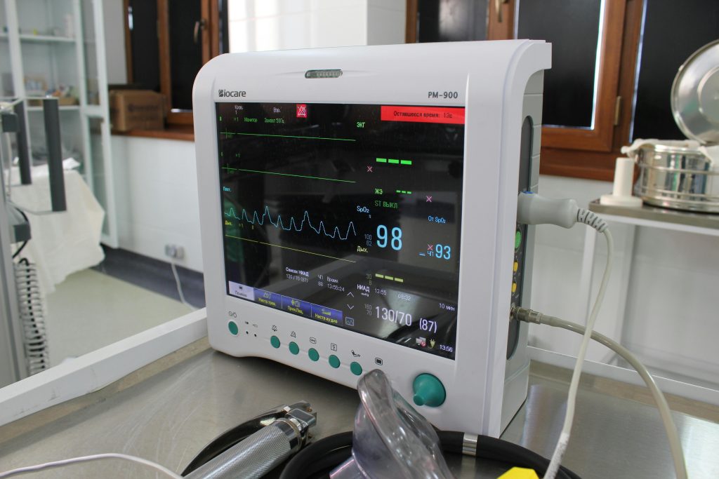 Close-up of an advanced medical monitor displaying ECG data in a clinic.